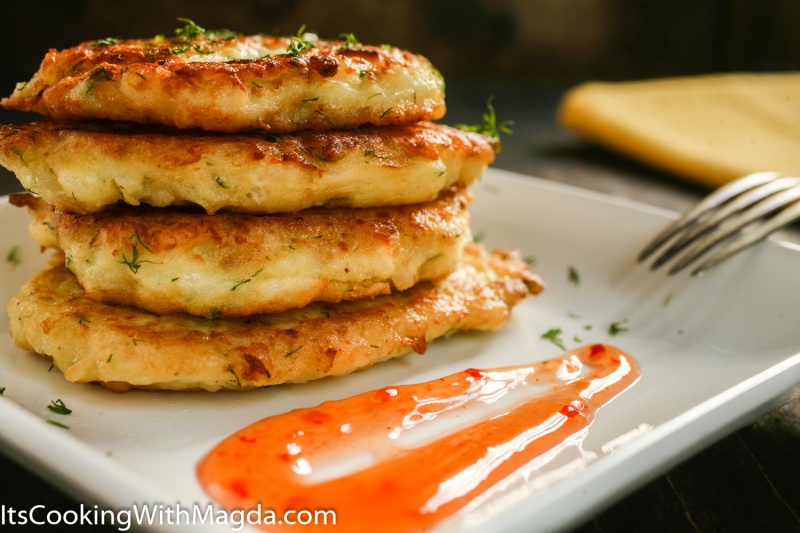 cauliflower fritters stacked on a white plate with sweet sauce